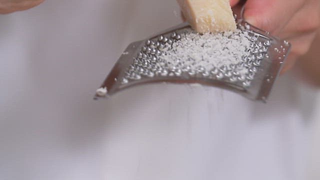 Sprinkle grated cheese over ratatouille with zucchini and tomatoes