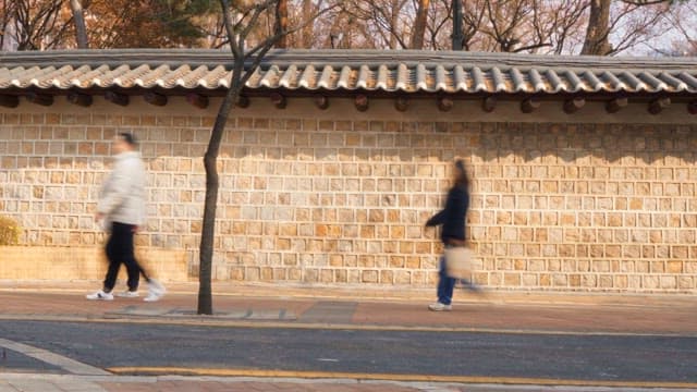 People walking along a traditional wall