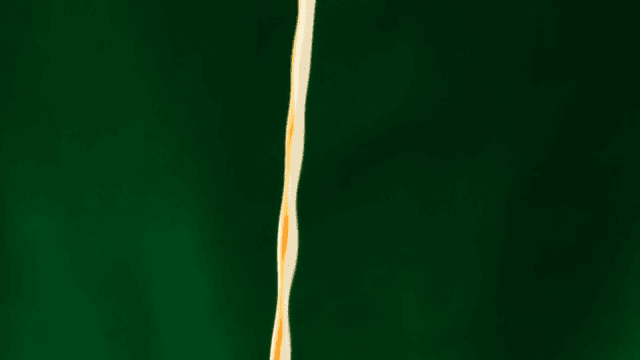 White milk and brown coffee poured against a green screen