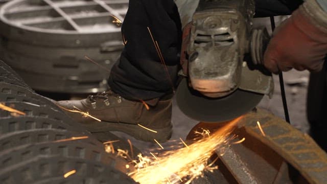 Worker using a grinder with sparks flying
