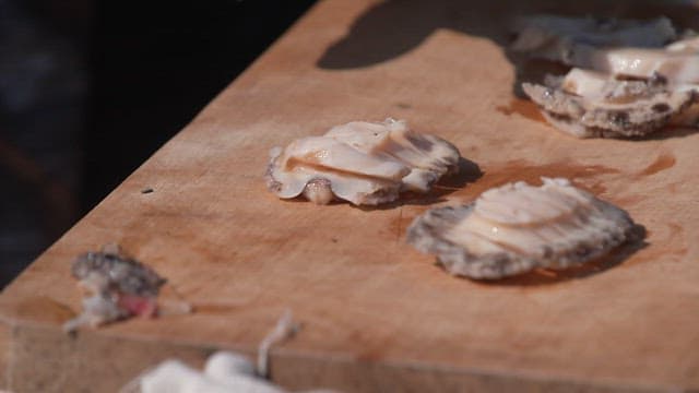Fresh raw abalone on a wooden cutting board