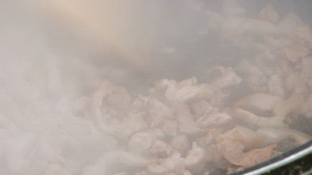 Pork being fried in a hot pan