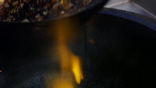 Stir-frying meat and vegetables in a wok with black bean paste