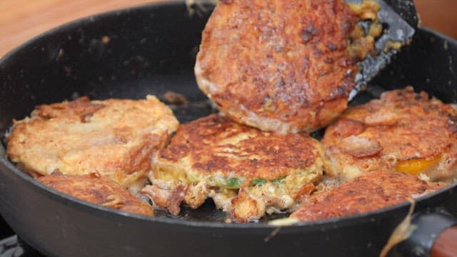 Meatballs of bell pepper fried until golden brown in a frying pan