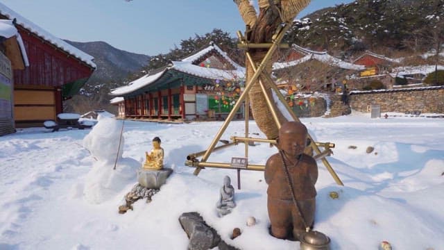 Snow-covered temple with Buddhist statues