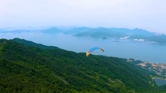 Paragliding Over Scenic Mountainous Landscape by the Sea