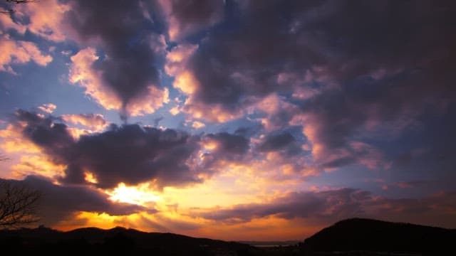 Sunset with vibrant clouds over mountains