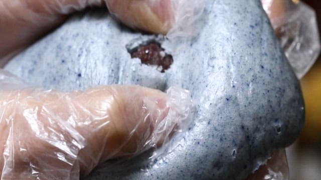 Steamed bun cut in half to reveal red beans inside