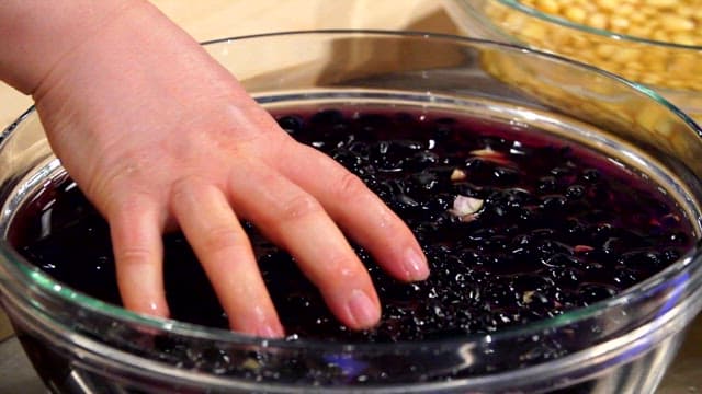 Washing black beans in a transparent bowl