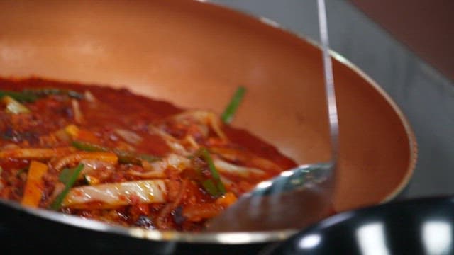 Pouring Spicy Stir-fry Sauce on Top of Noodles