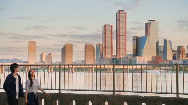 Couple walking by the river with cityscape