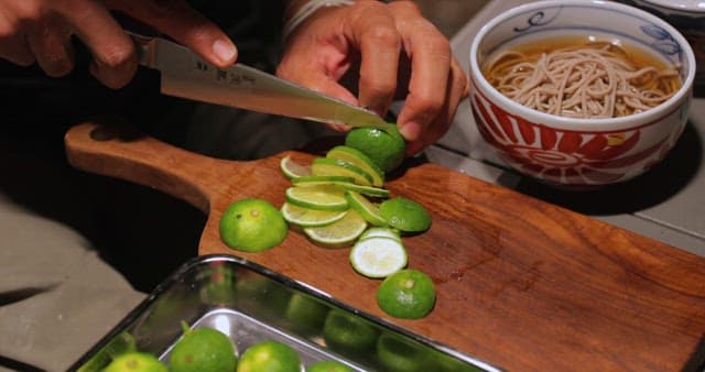 Preparing Citrus Fruits Beside Noodle Soup