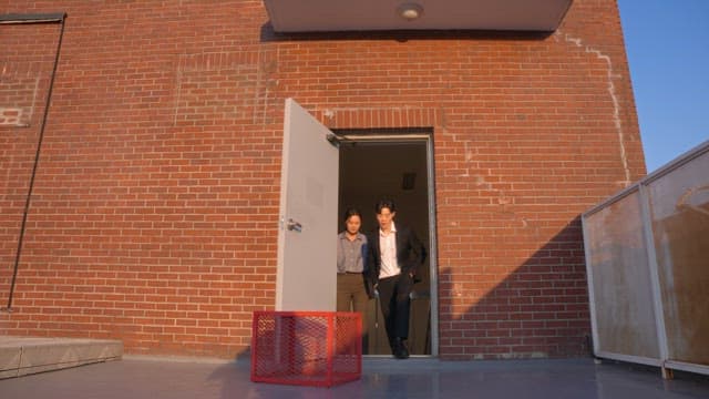 Two people stepping out onto a rooftop