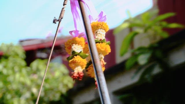 Yellow and orange marigold flower garlands hung on metal pole