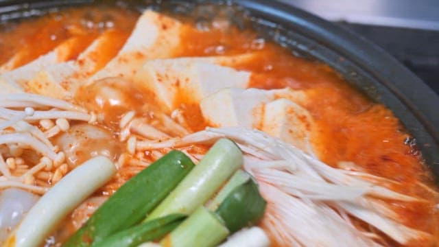 Steaming Pot of Korean Hot Tofu Soup with Fresh Ingredients