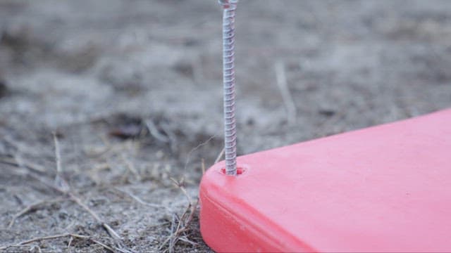 Hammer About to Strike a Nail on the Ground