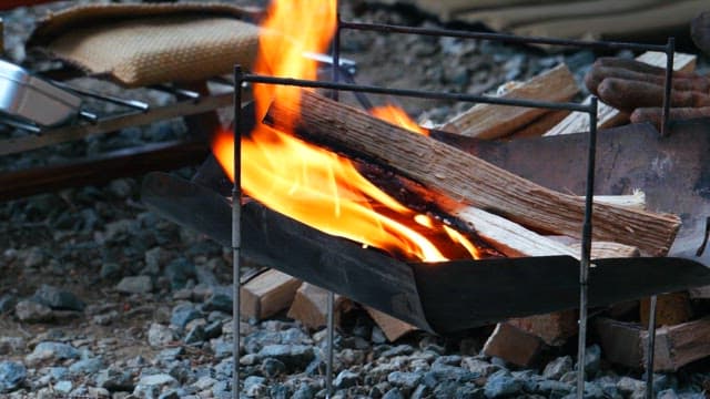 Campfire burning brightly with logs in the brazier at the evening