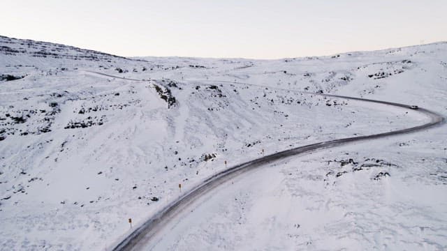 Car driving through a snowy mountain pass