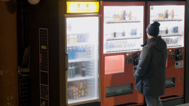 Person Selecting Drinks at a Vending Machine