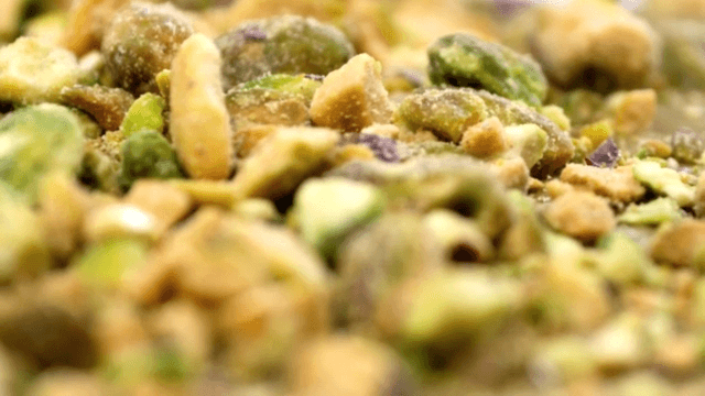 Crushed pistachio falling on thick surface