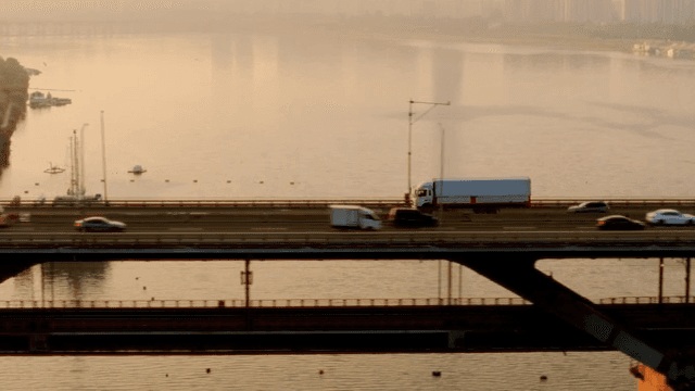Vehicles moving on a bridge at sunset