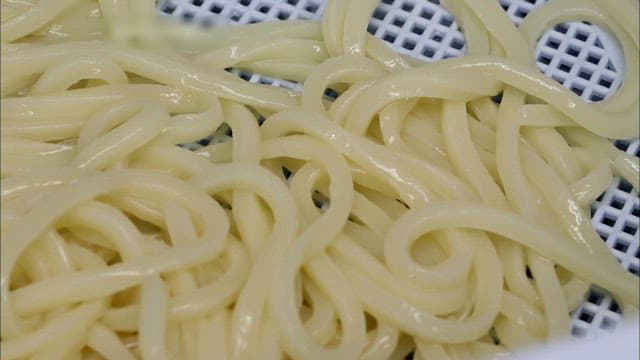Freshly cooked udon noodles on a tray