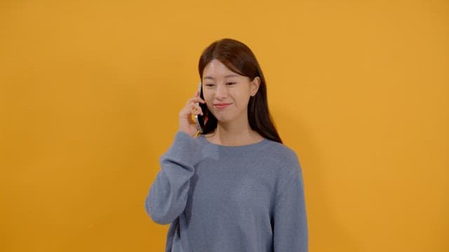 Front view of a long-haired woman talking on the phone
