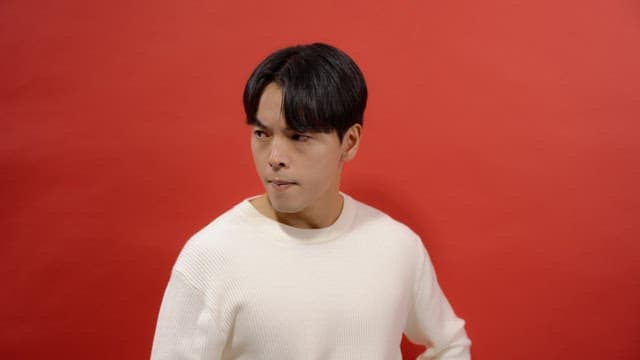 Man in a white sweater, breathing deeply with an angry expression