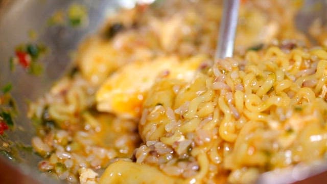 Lifting a spoonful of mixed ramyeon and rice