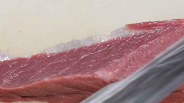 Slicing fresh yellow tail on a cutting board