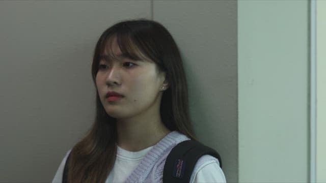 Young woman hiding in the school hallway