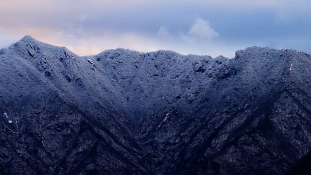 Snow-covered mountains under cloudy skies