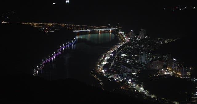 Riverside Cityscape at Night with Illuminated Bridge