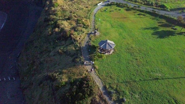 People climbing along the green mountain trail
