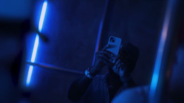 Person with Smartphone in Moody Lighting