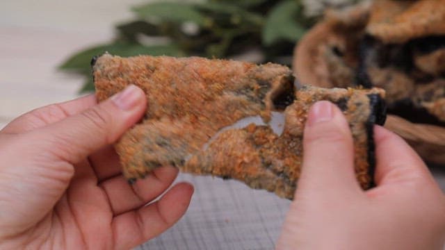 Hands breaking a crispy laver chip