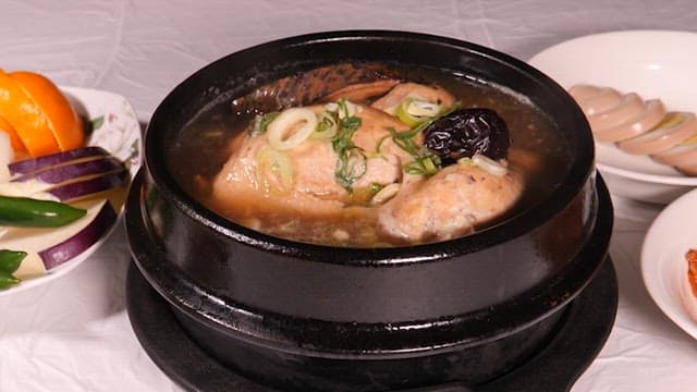 Steaming Bowl of Hearty Samgyetang with Fresh Vegetables