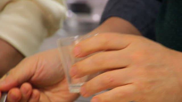 Preparing dessert by placing strawberry slices in a glass
