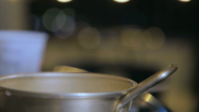 Pouring white makgeolli into a pot