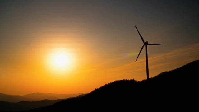 Changes in the sky from sunset to night above wind turbines