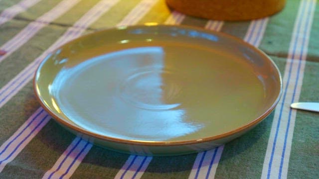 Fish steak and asparagus neatly placed on a plate on a cozy table