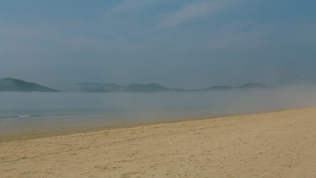 Misty Beach Morning with Distant Hills