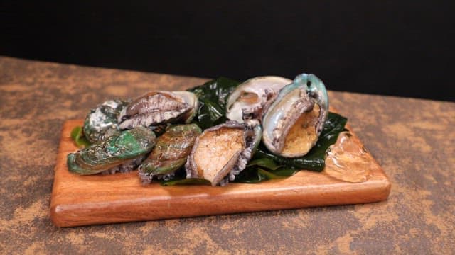 Fresh abalone displayed on a wooden board