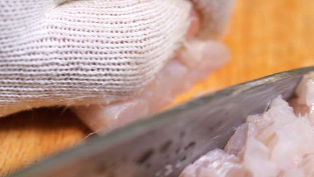 Fresh eel being neatly sliced ​​with a knife on a cutting board