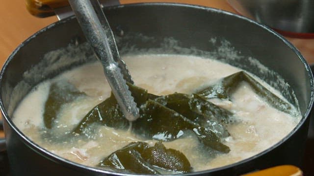 Kelp being removed from a pot for use as broth