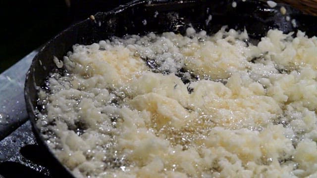 Batter being poured into hot oil for frying