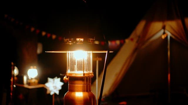 Illuminated Lantern in a Cozy Nighttime Camp