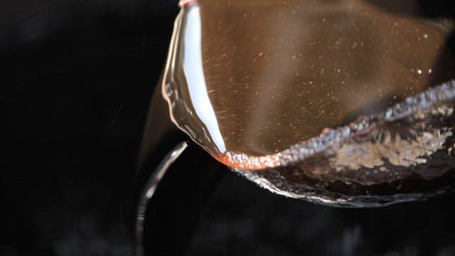 Soy sauce in a crock is slowly poured