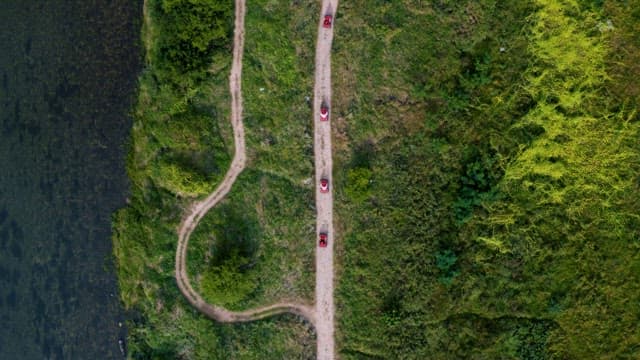 Recreational Car on a Narrow Dirt Road by the Riverside