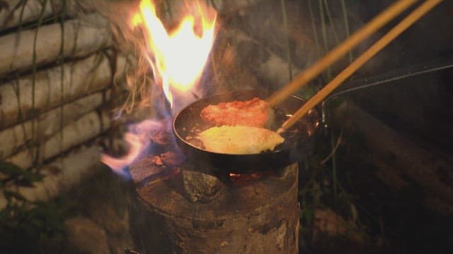 Cooking food over an open flame outdoors